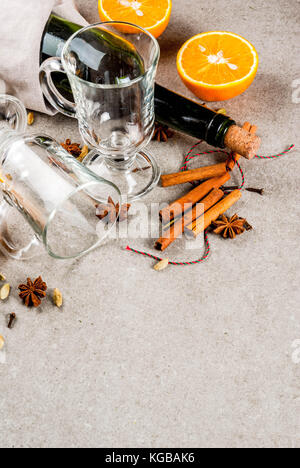Weihnachten heiße Getränke Rezepte, von Zutaten für Glühwein: Wein Flasche, Glas Tassen, Gewürze, orange. grauen Stein Hintergrund Kopie Raum Stockfoto
