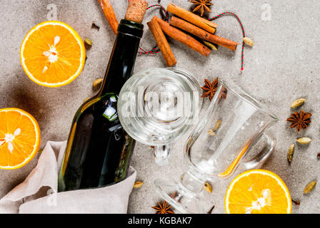Weihnachten heiße Getränke Rezepte, von Zutaten für Glühwein: Wein Flasche, Glas Tassen, Gewürze, orange. grauen Stein Hintergrund einzurichten, kopieren Sie Raum, Ansicht von oben Stockfoto