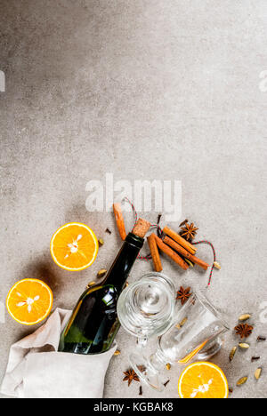 Weihnachten heiße Getränke Rezepte, von Zutaten für Glühwein: Wein Flasche, Glas Tassen, Gewürze, orange. grauen Stein Hintergrund einzurichten, kopieren Sie Raum, Ansicht von oben Stockfoto