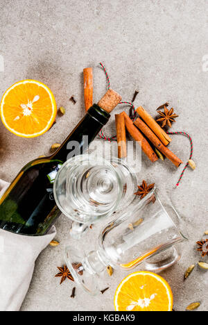 Weihnachten heiße Getränke Rezepte, von Zutaten für Glühwein: Wein Flasche, Glas Tassen, Gewürze, orange. grauen Stein Hintergrund einzurichten, kopieren Sie Raum, Ansicht von oben Stockfoto
