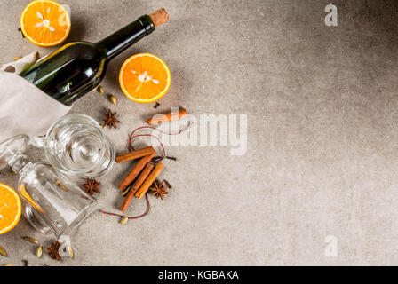 Weihnachten heiße Getränke Rezepte, von Zutaten für Glühwein: Wein Flasche, Glas Tassen, Gewürze, orange. grauen Stein Hintergrund einzurichten, kopieren Sie Raum, Ansicht von oben Stockfoto