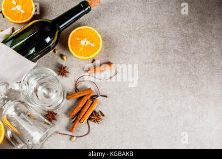 Weihnachten heiße Getränke Rezepte, von Zutaten für Glühwein: Wein Flasche, Glas Tassen, Gewürze, orange. grauen Stein Hintergrund einzurichten, kopieren Sie Raum, Ansicht von oben Stockfoto