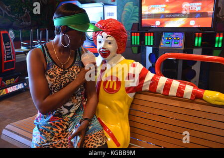 Frau auf dem Schoß der Statue bei McDonald's auf dem International Drive, Orlando Stockfoto