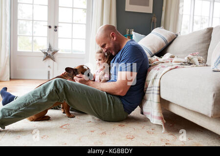 Vater und Tochter entspannt mit ihrem Hund zu Hause Stockfoto