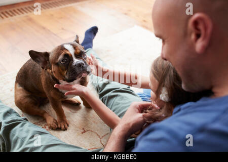 Junges Mädchen mit Papa, Streichelzoo Hund zu Hause, über die Schulter sehen Stockfoto