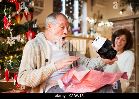 Senior Paar vor Weihnachtsbaum mit VR-Brille. Stockfoto
