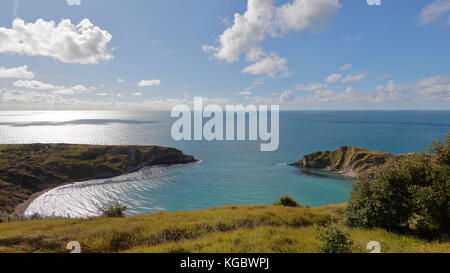 Weitwinkel Blick über Lulworth Cove an einem klaren Herbstmorgen von South West Coast Path mit fernen Portland isle Kulisse, Jurassic Coast, Dorset UK Stockfoto