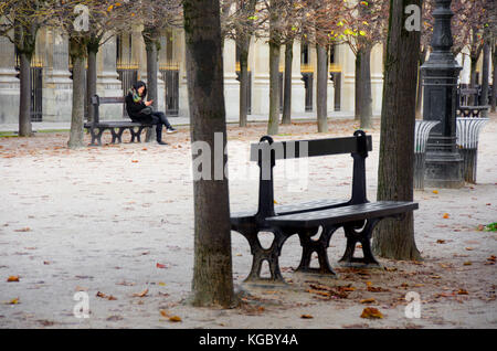 Paris, Frankreich. Palais Royal. Herbst, Frau entspannend auf einer Bank Stockfoto