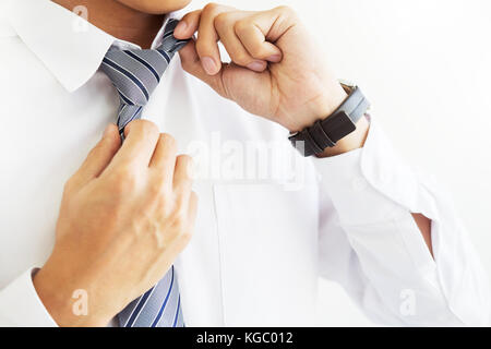 Mode und Kleidung Konzept - bis Geschäftsschluss Mann im Hemd Dressing up und Einstellung der Riegel am Hals Stockfoto
