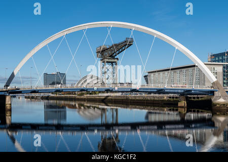 Die Clyde Arc-AKA Die Squinty Brücke - mit der SEC Armadillo und FInnieston Kran im Hintergrund Stockfoto