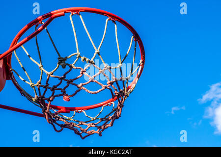 Basketballkorb im Freien, Nahaufnahme, Low Angle View. rot Basketballkorb von unten gegen den blauen Himmel gesehen. Stockfoto