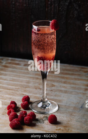 Ein Glas Champagner auf rustikalen Hintergrund Himbeere Stockfoto