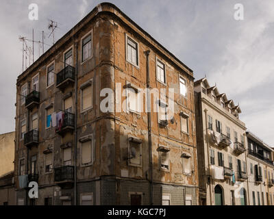 Alten verfallenen Wohnhaus mit Wäsche trocknen von Balkonen in typischen Lissabonner Straße Stockfoto