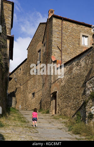 Ein kleines Mädchen steigt den steilen Hang neben dem Kloster Santa Trinità, Via San Niccolò, Cortona, Arezzo, Toskana, Italien Stockfoto