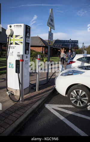 Nissan Leaf Electric Car an einer Ladestelle an einer Autobahn-Tankstelle. VEREINIGTES KÖNIGREICH Stockfoto