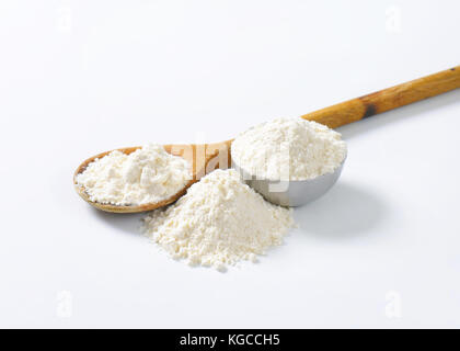 Mehl aus Weichweizen auf Löffel aus Holz und Metall Schüssel auf weißem Hintergrund Stockfoto