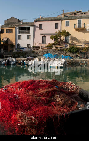 Korsika: Fish Nets und Fischerboote in centuri Port, die kleine Hafenstadt am Cap Corse Halbinsel, auf der westlichen Seite des Cap Corse Stockfoto