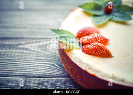 Frische Käsekuchen mit Beeren auf einem hölzernen Hintergrund. Platz kopieren Stockfoto