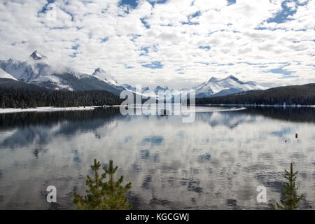 Ein Boot, Reflexionen, Schnee & Berge - Maligne Lake im Jasper National Park, Alberta, Kanada Stockfoto