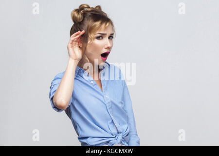 Ich kann Sie nicht hören. Schöne junge Dame. studio Shot, grauer Hintergrund Stockfoto