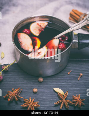 Glühwein im Aluminium Pfanne mit einer auf einem schwarzen Hintergrund Griff aus Holz, Ansicht von oben Stockfoto
