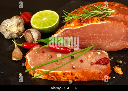 Raw Schweinekoteletts mit Gewürzen. geschnittene Fleisch auf dem Grill zubereitet Stockfoto