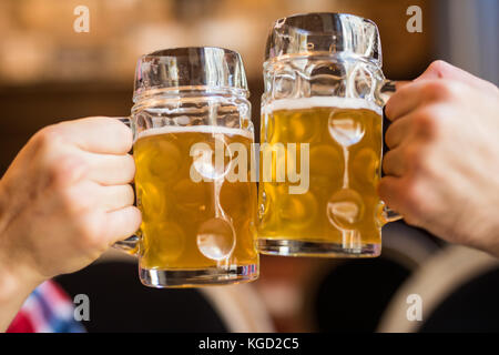 Close-up von Menschen Toasts mit einem Bier in der Kneipe. Bier Prost Stockfoto