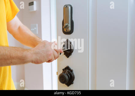 Nahaufnahme eines professionellen Bauschlosser installieren oder Reparieren eines neuen deadbolt Verschluss Stockfoto