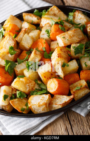 Gebackener Sellerie und Karotten close-up auf einem Teller auf dem Tisch. Vertikale Stockfoto