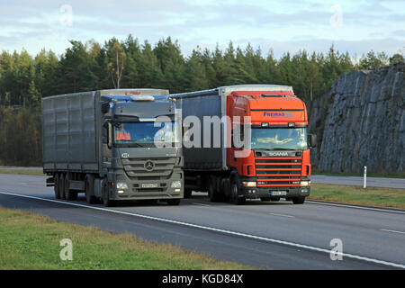 Paimio, Finnland - 16. Oktober 2015: Scania 124l semi überholt einen Lkw auf der Autobahn Lkw mit schwere Ladung viel langsamer bergauf werden kann. Stockfoto