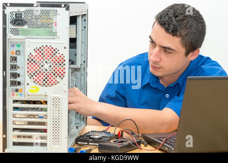 Ein junger Techniker arbeiten an defekten Computer in seinem Büro Stockfoto
