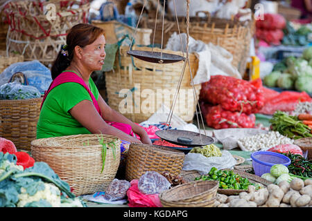 Burmesischen Frau mit thanaka auf ihrem Gesicht verkaufen Gemüse am Markt im Dorf entlang Inle See, nyaungshwe, Shan Staat, Myanmar/Burma Stockfoto