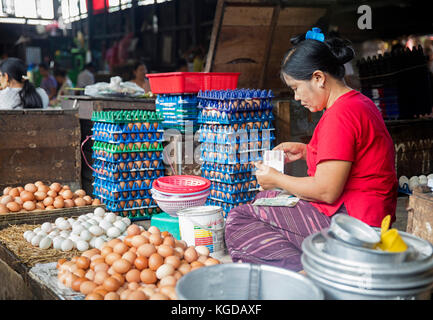 Burmesischen Frau verkauft Eier und zählen Geld am Markt in Yangon/Rangun, Myanmar/Burma Stockfoto