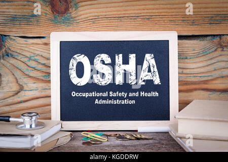 Osha, Behörde für Sicherheit und Gesundheitsschutz am Arbeitsplatz. Tafel auf einem hölzernen Hintergrund Stockfoto
