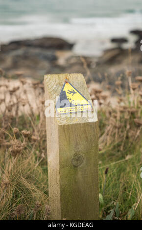 Instabiles Klippenrandschild warnt vor der Gefahr von fallenden Felsen und Sturz über den Rand in Cornwall, England, Großbritannien Stockfoto