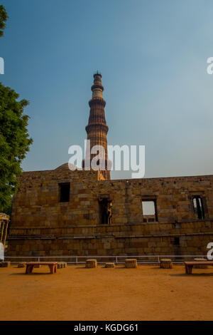 DELHI, INDIEN - 25. SEPTEMBER 2017: Qutub Minar hinter alten Steinstrukturen befindet sich Qutub eines der UNESCO-Welterbe, erbaut im frühen 13. Jahrhundert im Süden von Delhi, Indien Stockfoto