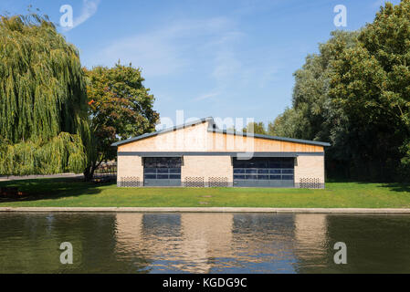 Kleine Lager Depot in Ziegel und Holz am Ufer eines Flusses mit Garten und großen Bäumen gebaut um Sie herum Stockfoto