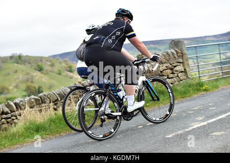 Übergewicht Radfahrer Radfahren bergauf in Yorkshire, Großbritannien Stockfoto