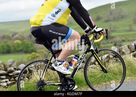 Übergewicht Radfahrer Radfahren bergauf in Yorkshire, Großbritannien Stockfoto