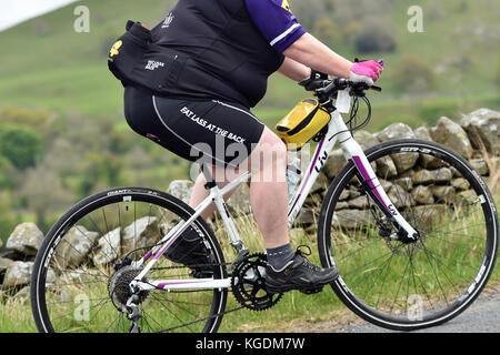 Übergewicht Radfahrer Radfahren bergauf in Yorkshire, Großbritannien Stockfoto