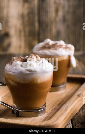 Pumpkin spice Latte garniert mit Sahne und Pumpkin Pie Gewürze, traditionelle fallen Lieblingsgetränk Stockfoto
