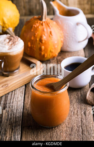 Kürbispüree und Zutaten für die Zubereitung Kürbis spice Latte mit Schlagsahne und Kürbistorte Gewürze, traditionelle fallen Lieblingsgetränk Stockfoto