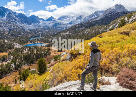 Wanderer am Overlook by Mono Pass Trail sehen herbstliche Farben im Little Lakes Valley am Rock Creek Canyon in Kalifornien, etwa 40 km von Mammoth Lakes entfernt Stockfoto