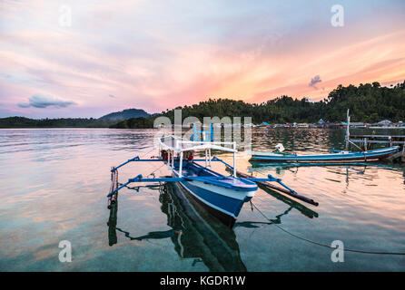 Einen atemberaubenden Sonnenuntergang über einem traditionellen Boot in katupat in der togian (oder togean) Inseln in Sulawesi, einer abgelegenen Ecke Indonesiens in der celebes See. Stockfoto