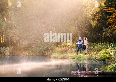 Senior paar Angeln am See im Herbst. Stockfoto