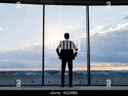 Reifen Geschäftsmann stand am Fenster in einem Hotel. Stockfoto