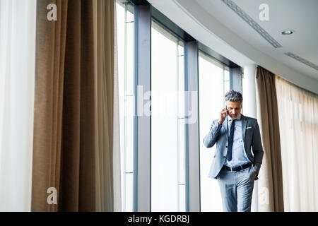 Reifen Geschäftsmann mit Smartphone in ein Hotel. Stockfoto
