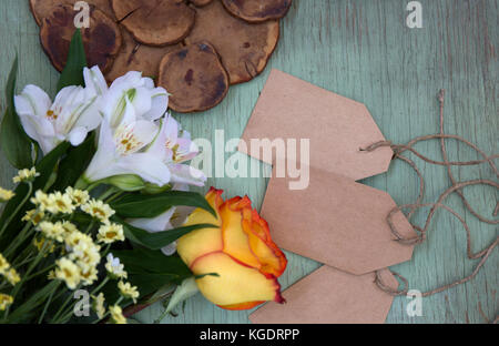 Mockup mit leeren Kraftpapier Etiketten. leere Blatt. Ein Ort für die Präsentation. wilde Blumen auf grün lackierten Holz- Hintergrund. Stockfoto