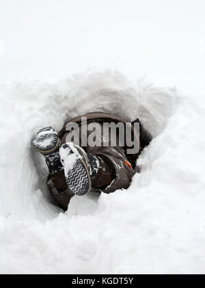 Junge tragen Winter Jacke spielen in Snow Drift Stockfoto