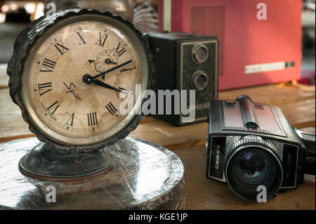 Eine Vintage-Uhr und Kameras auf dem Tisch eines lokalen Marktes. Stockfoto